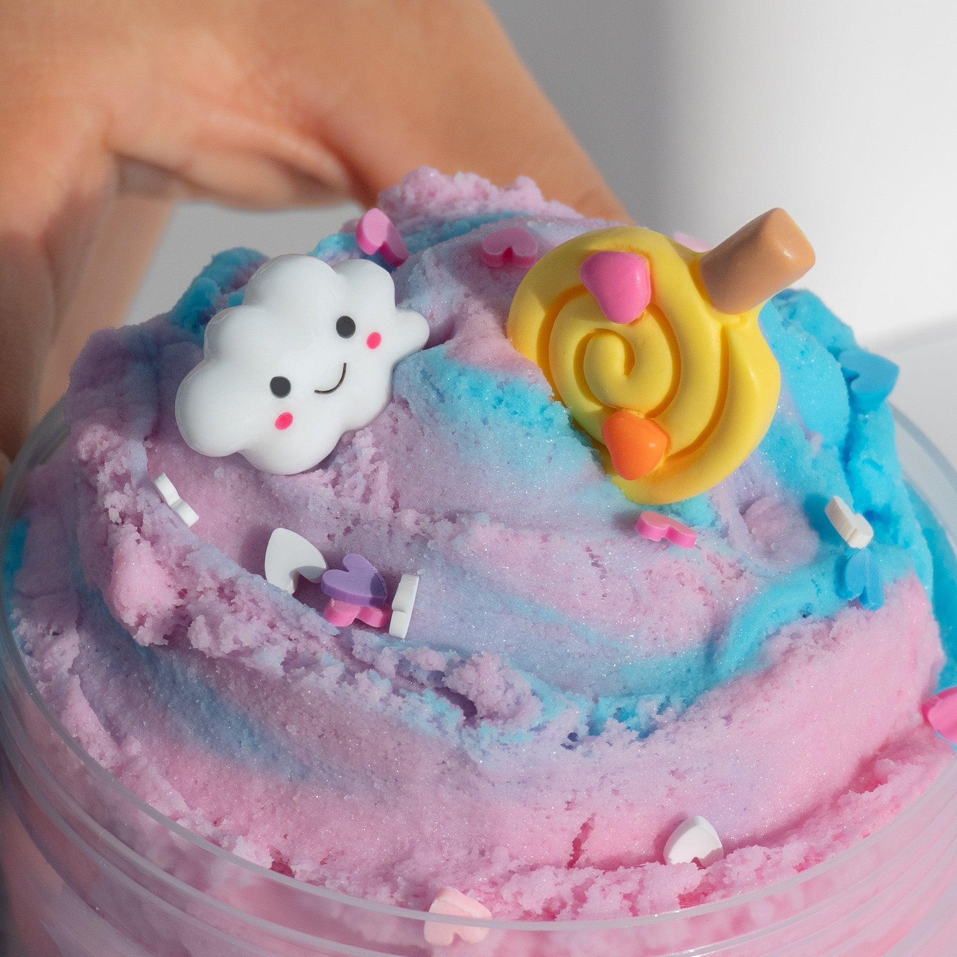 A close-up of the Cotton Candy Fluff slime’s cloud-like texture, showcasing vibrant pastel colors and fun charms, including heart-shaped sprinkles.