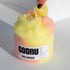 A hand adjusting the lemon slice charm on the Pink Lemonade slime, emphasizing its icy texture and citrusy details.