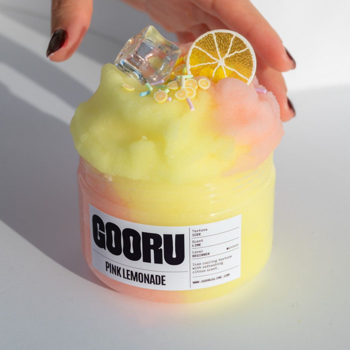The Pink Lemonade slime jar displayed in natural light, showcasing its dual-colored ice texture and playful citrus decorations.