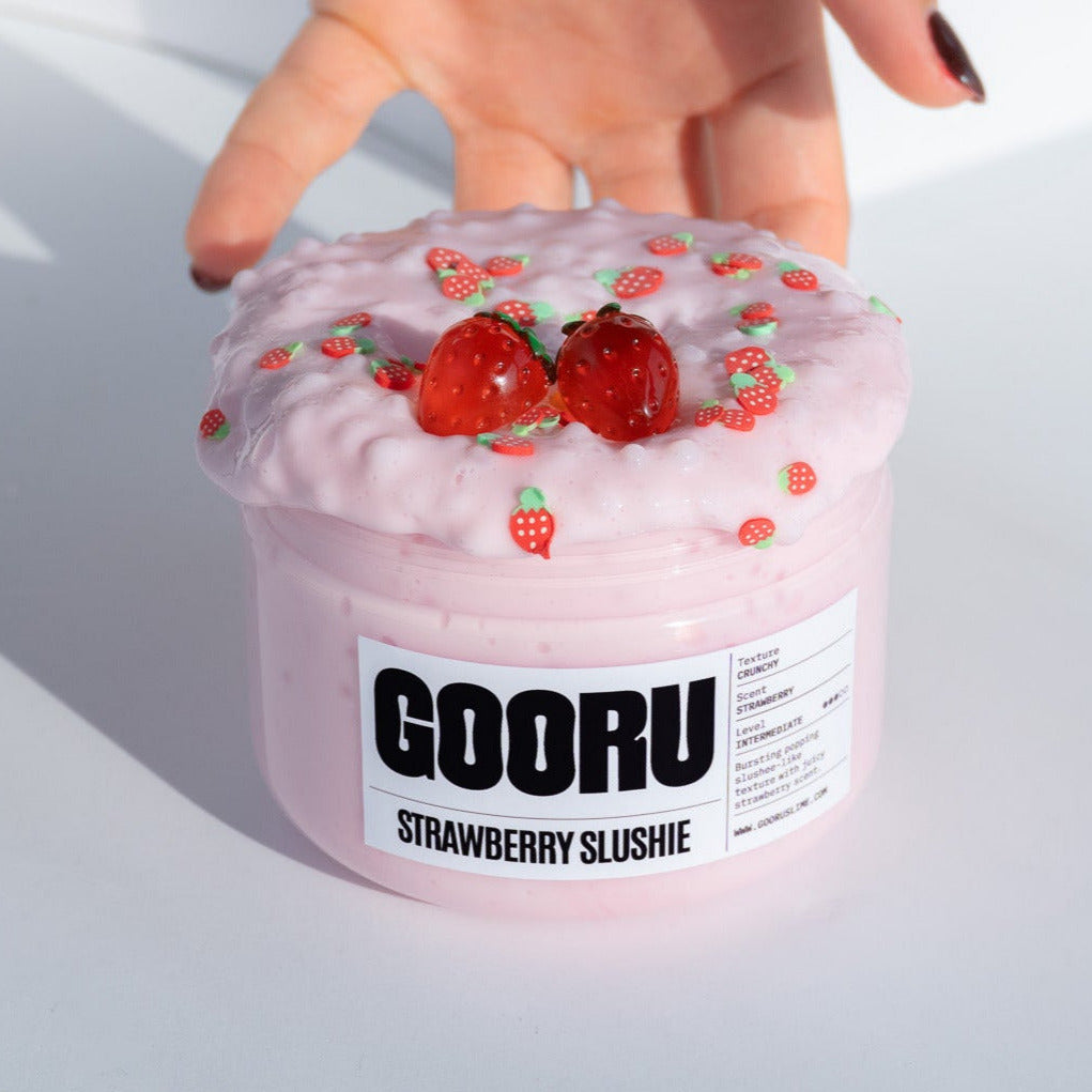 The Strawberry Slushie slime jar displayed with its vibrant pink texture and strawberry-themed details, capturing its playful design.
