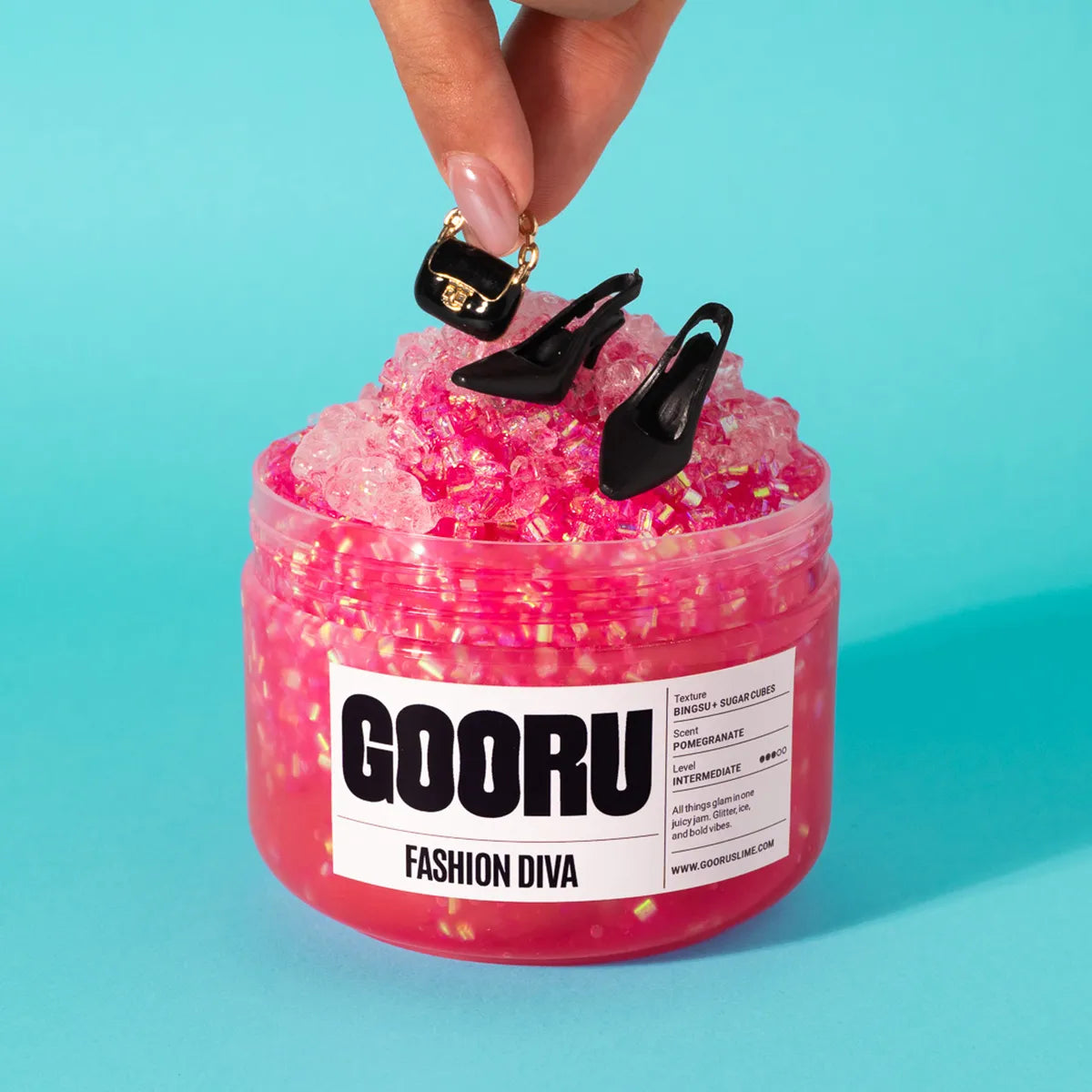 Pink glittery slime jar with black high heels and 'GOORU' label on a teal background