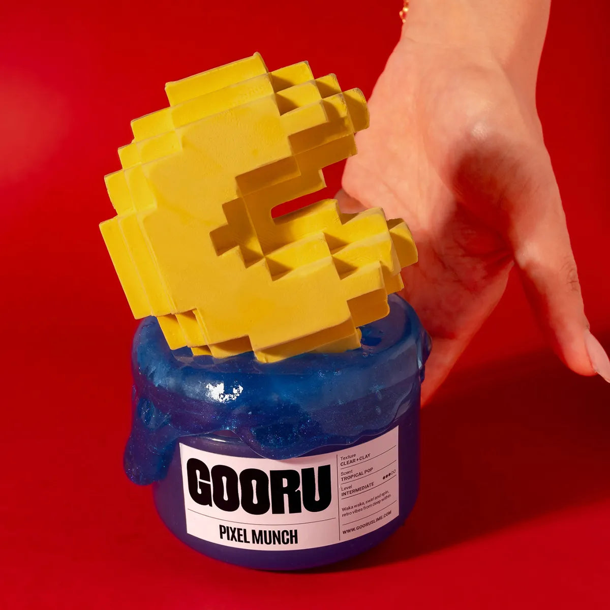 Yellow pixelated character on a blue slime container with 'GOORU' branding against a red background