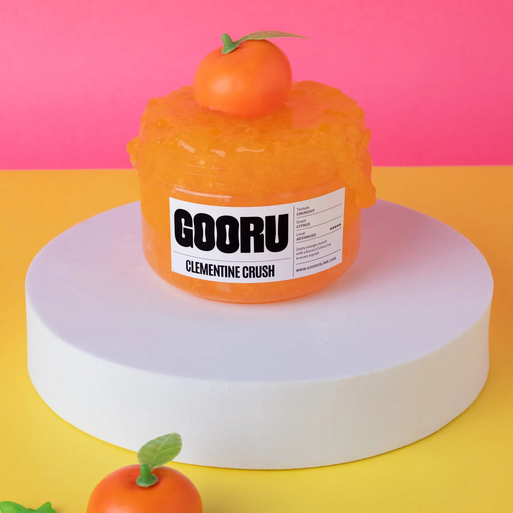 Orange jelly-like product with a label on a pink and yellow background