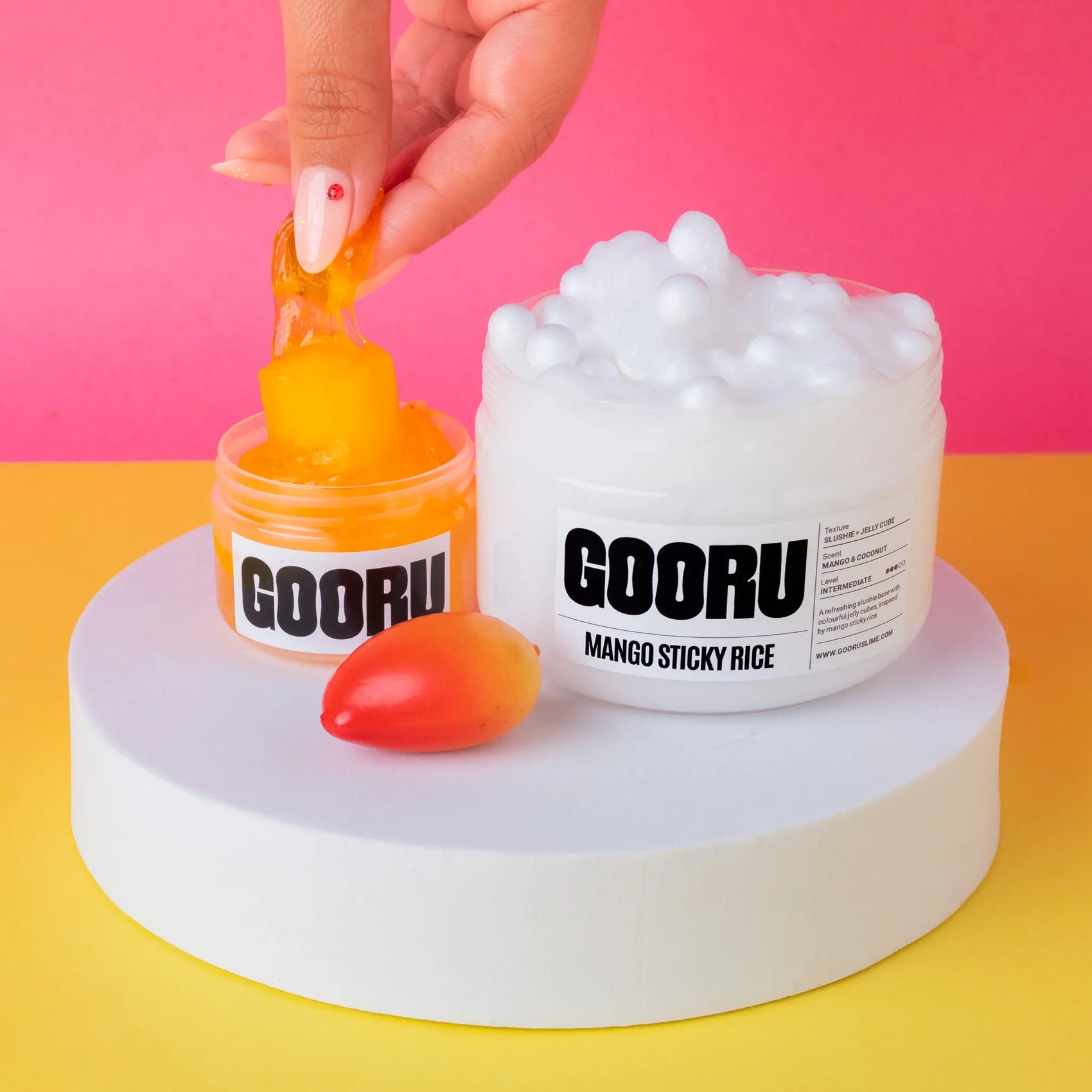 GOORU Mango Sticky Rice slime with a hand interacting on a colorful background