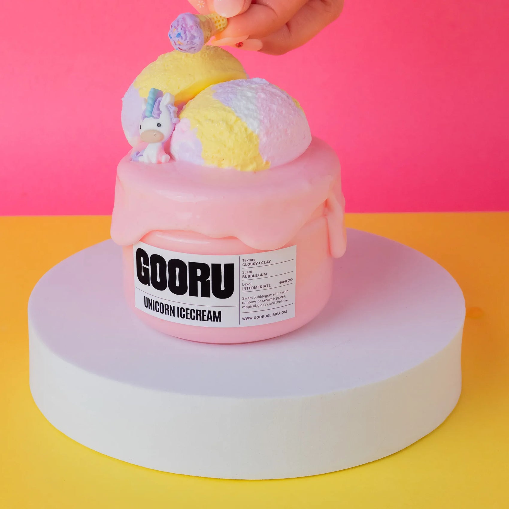 Pink slime container with unicorn-themed elements on a pink and yellow background