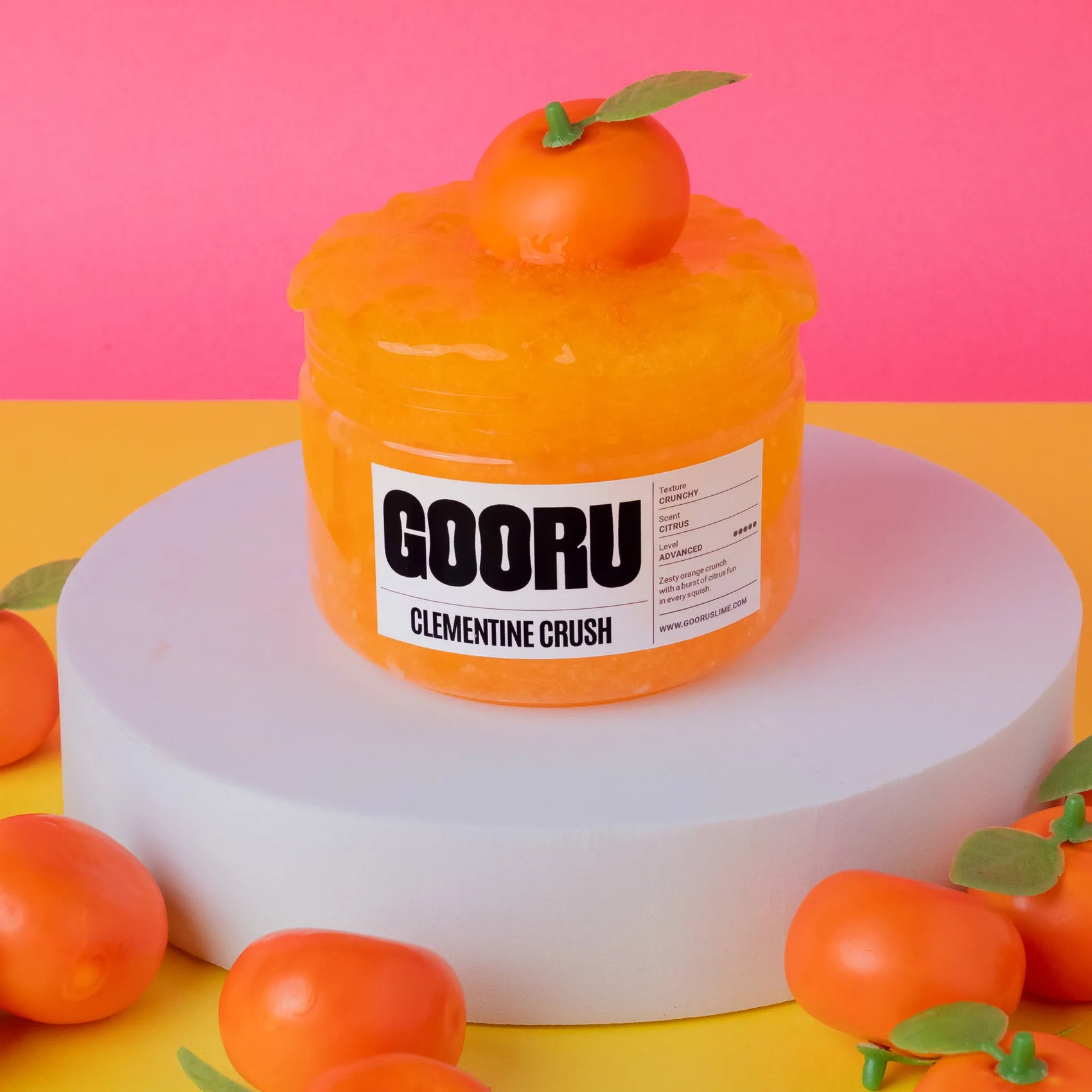Orange container labeled 'GOORU Clementine Crush' on a pink and yellow background