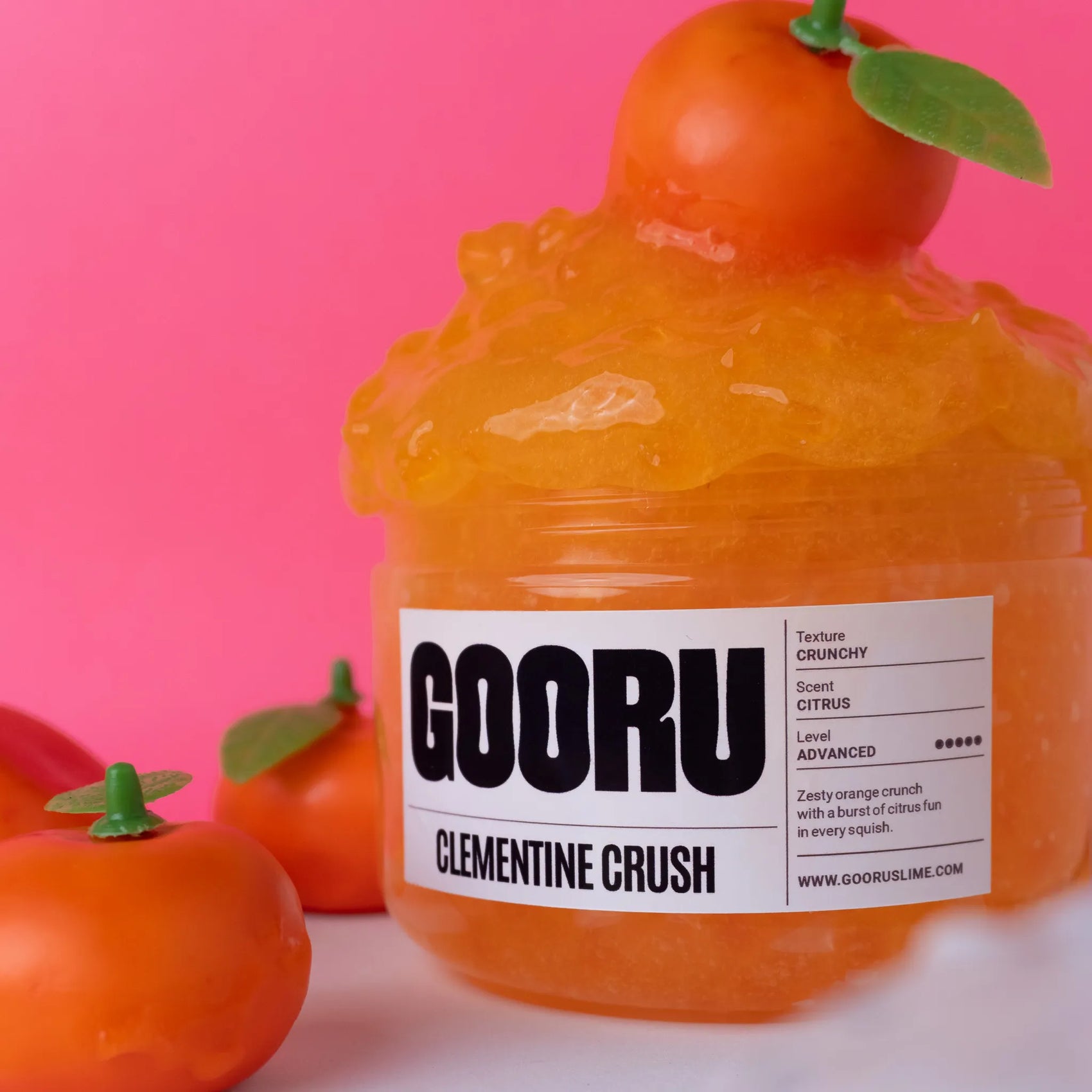 Orange slime container labeled 'GOORU Clementine Crush' with a pink background