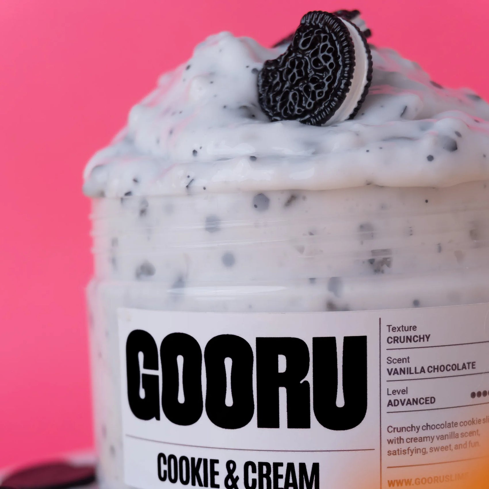 Jar of GOORU Cookie & Cream product with an Oreo cookie on a pink background