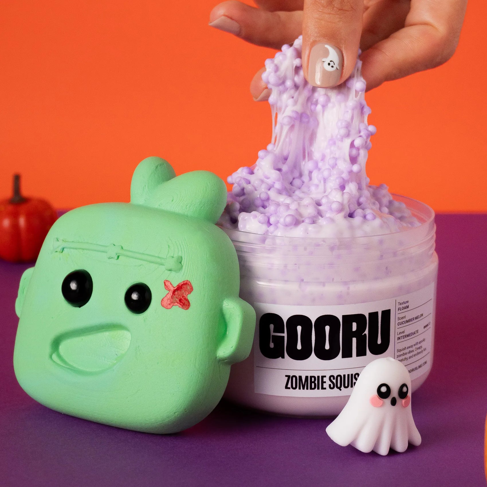 Green zombie-shaped container with purple slime next to it on a colorful background