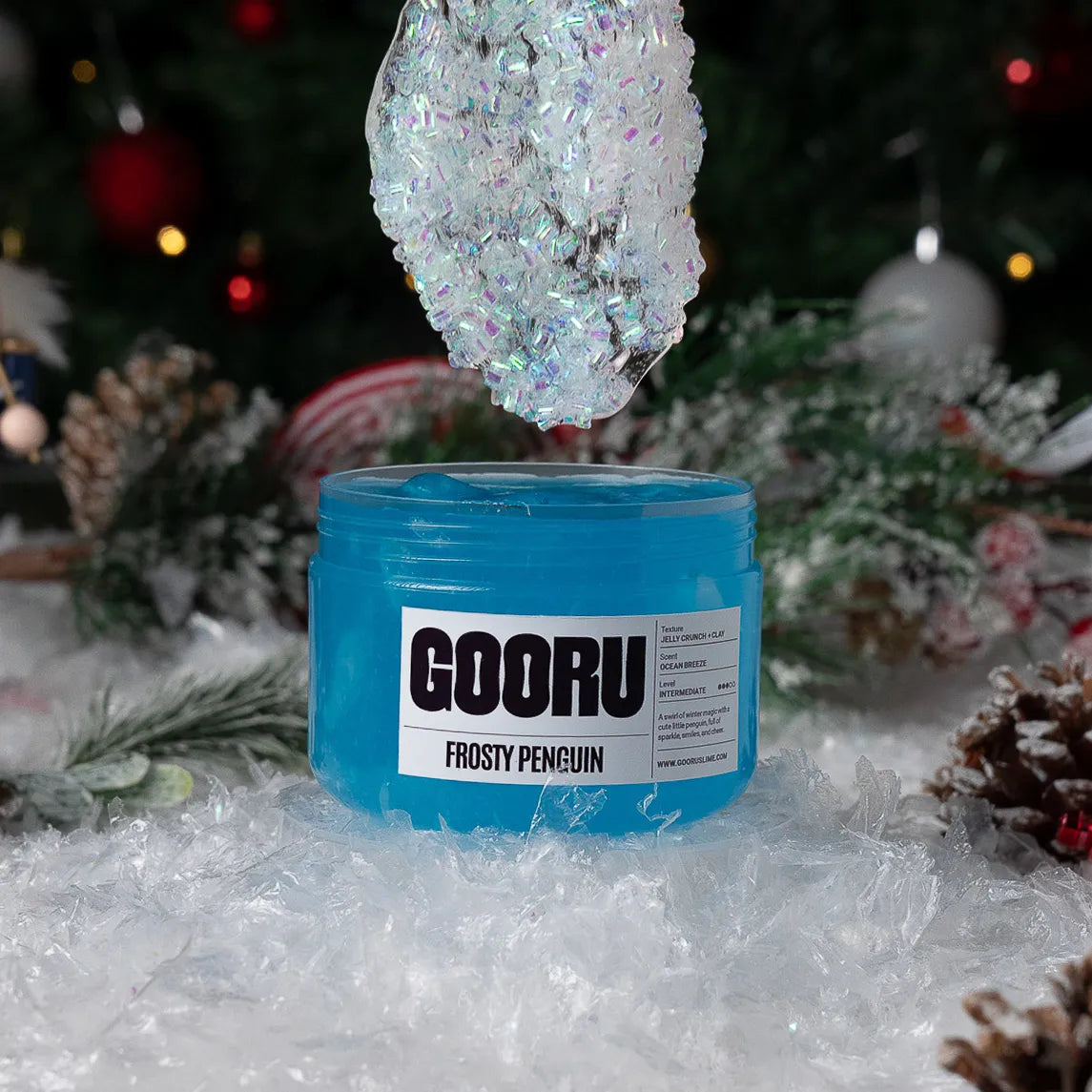Blue container labeled 'GOORU Frosty Penguin' with decorative ice crystal against a festive background.